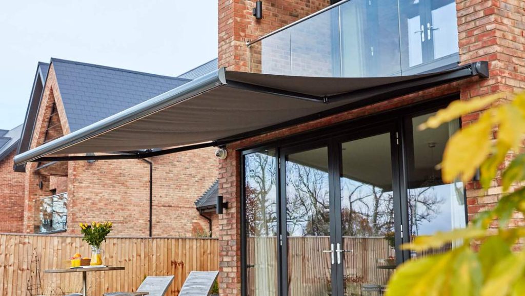 a closer up shot of a retractable awning above a back glass double patio door