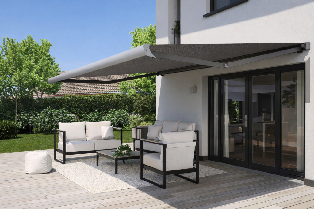 awning installation east sussex - a photo of an awning extended from the back of a home over black metal frame patio furniture with thick white cushions