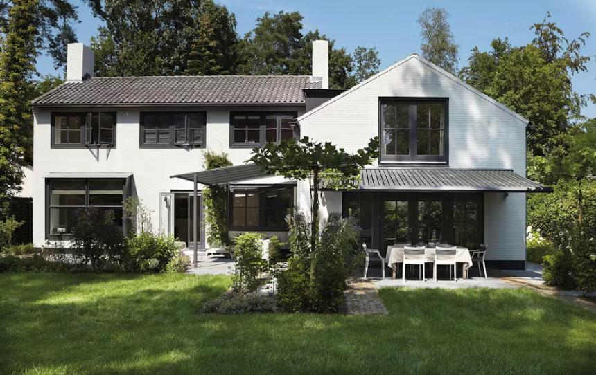 a home witha lush green garden and two awnings extended with remote control operation